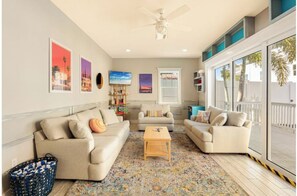 A living room with two sofas, a coffee table, and a bookshelf. - Key West Style Apartment - with pool/hot-tub (Dunedin)