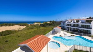 Ein Resort mit Swimmingpool, Blick auf den Strand und mehrstöckigen Gebäuden.