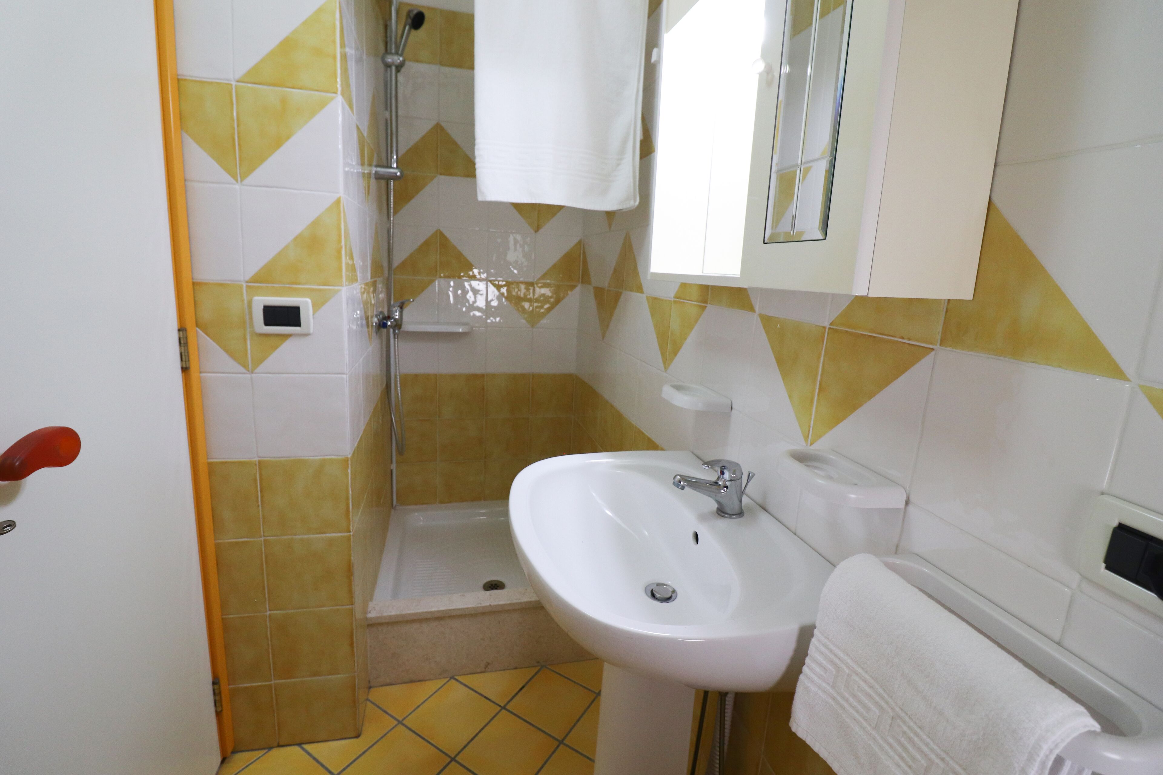 A bathroom with a shower, sink, and toilet.