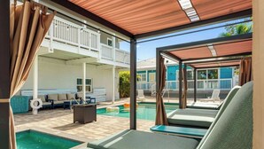 A poolside area with lounge chairs, a small pool, and a covered patio. - Key West Style Apartment - with pool/hot-tub (Dunedin)