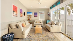 A living room with two sofas, a coffee table, and a bookshelf. - Key West Style Apartment - with pool/hot-tub (Dunedin)