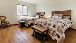 A bedroom with two beds, a wooden bench, a window, and a chair. - Beautiful Jefferson River Cabin w/ Mountain Views! (Twin Bridges)
