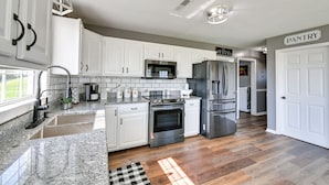 A modern kitchen with white cabinets, granite countertops, stainless steel appliances, and a sign indicating the pantry area. - Quiet Kentucky Vacation Rental w/ Hot Tub (Berry)