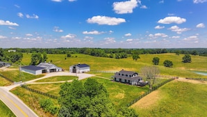 A rural landscape with a large barn, a farmhouse, and a fenced pasture. - Quiet Kentucky Vacation Rental w/ Hot Tub (Berry)