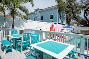 Relax in a serene outdoor space with a pool, surrounded by lush greenery and a charming fence.
