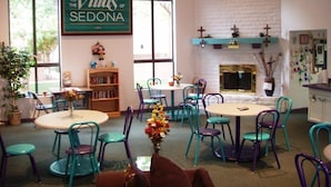 A cozy room with a fireplace, a bookshelf, and a sign reading "Villas of Sedona." - Capital Vacations Sedona Springs Resort - 1 Bedroom (3-Night) (Sedona)