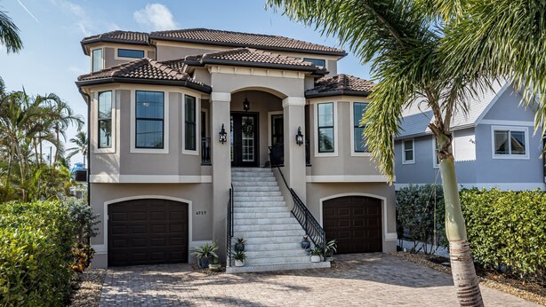 A two-story house with a central entrance, a staircase, and two garage doors.