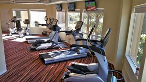 A gym with treadmills, stationary bikes, and a rowing machine.
