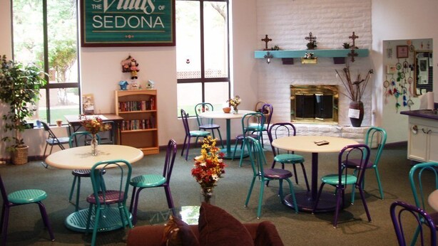 A cozy room with a fireplace, a bookshelf, and a sign reading "The Villas of Sedona".