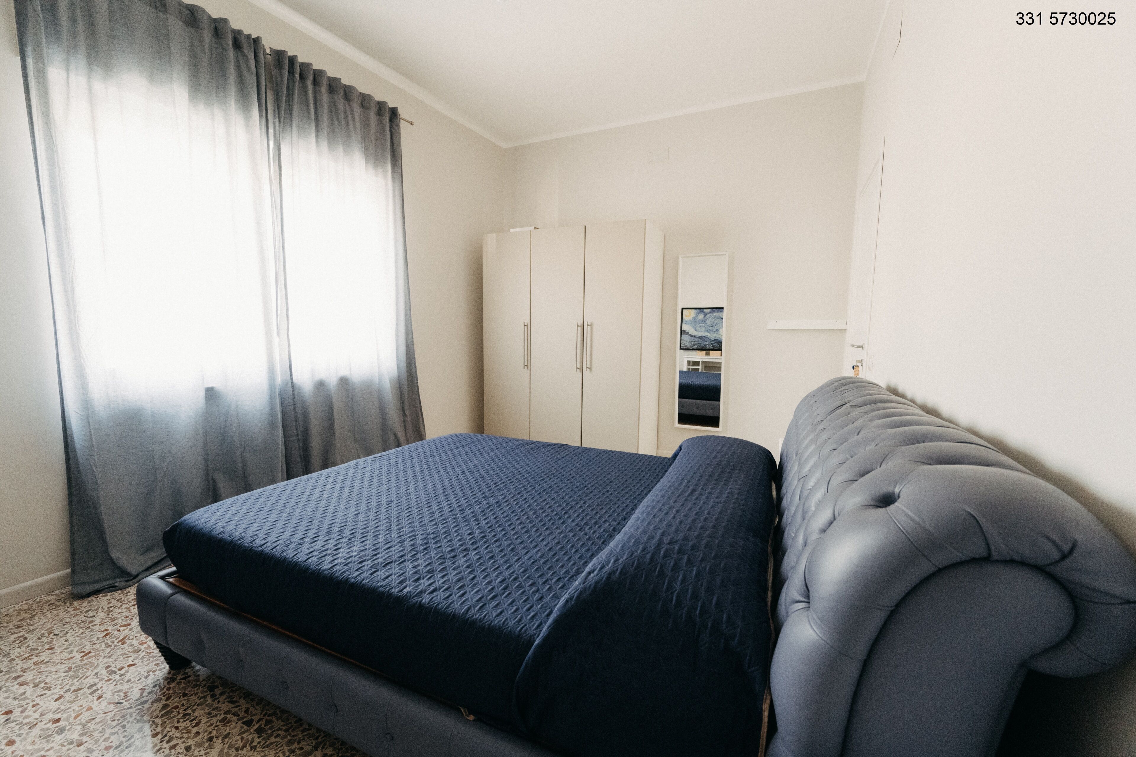 A bedroom with a bed, a wardrobe, and a television.