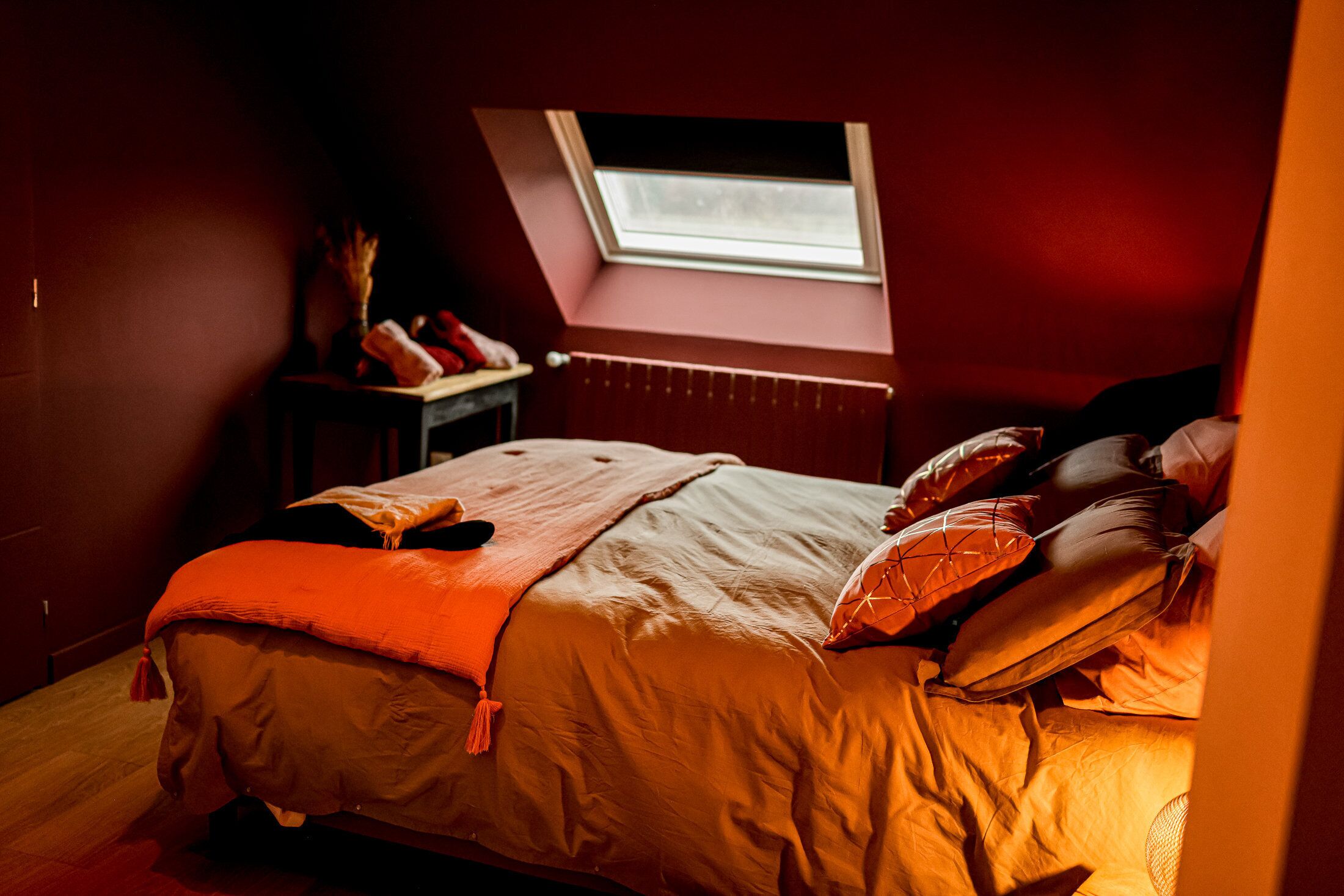 A bedroom with a bed, a window, and a radiator.