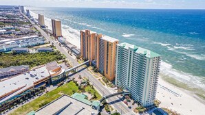 Un hotel costero con vista a la playa, varios edificios altos y un estacionamiento.