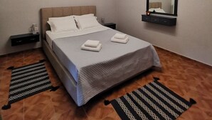 Un dormitorio con cama, mesitas de noche, un espejo y una lámpara en el techo.