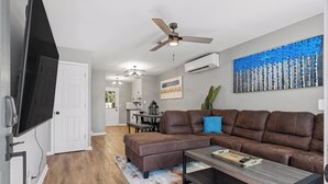A modern living room with a brown leather sofa, a coffee table, and a flat-screen TV mounted on the wall. - 2 Bed w/ Fenced Yard * Dog Friendly * Fox Den E (Pensacola)