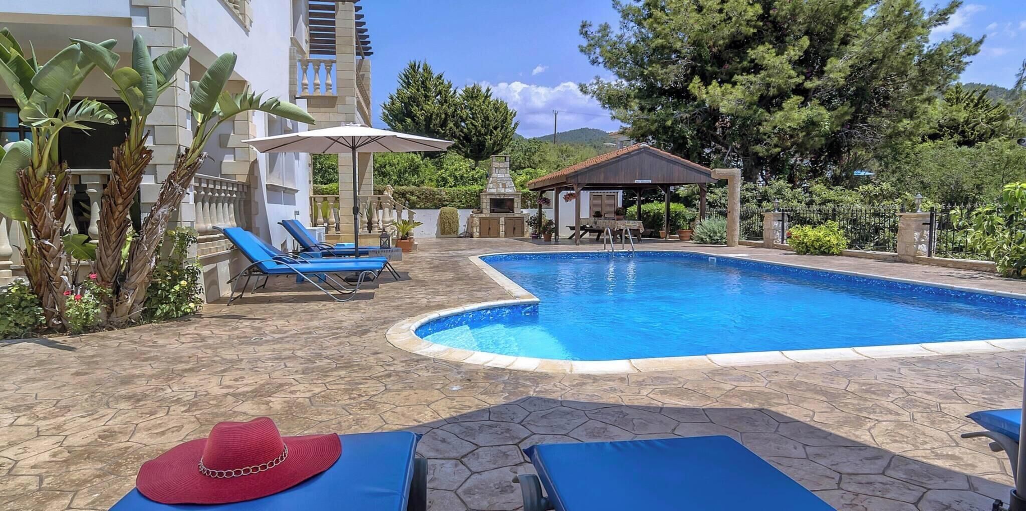 Une piscine dotée de chaises longues et d’un espace salon abrité.