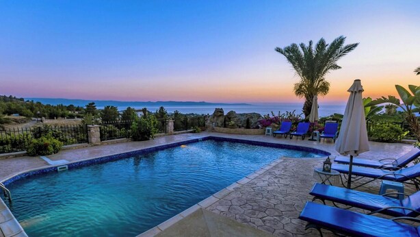 A swimming pool with a view of the sea and mountains, surrounded by lounge chairs and umbrellas. - Away-from-it-all, Exceptional Sea Views Sleeps 10 (Ayia Marina Chrysochous)