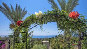 An outdoor archway with climbing plants and flowers, overlooking a coastal landscape. - Away-from-it-all, Exceptional Sea Views Sleeps 10 (Ayia Marina Chrysochous)