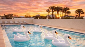 A swimming pool with swan-shaped inflatable floats.