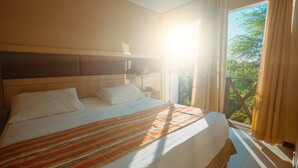 A hotel room with a large bed, a headboard, a nightstand, and a window with curtains. - Hotel Villaoeste (Mossoro)