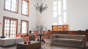 A spacious lobby with a reception desk, seating area, and a chandelier. - Hotel Villaoeste (Mossoro)