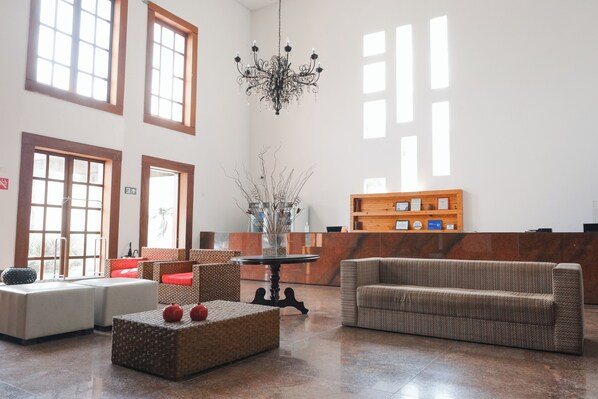 A spacious lobby with a reception desk, seating area, and a chandelier. - Hotel Villaoeste (Mossoro)