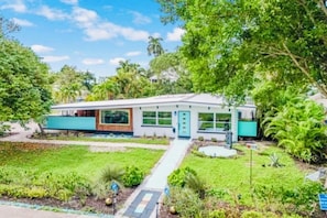A modern house with a front yard, a pathway, and a small garden area.