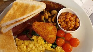 A breakfast plate with toast, scrambled eggs, bacon, sausages, fried potatoes, baked beans, and cherry tomatoes. - Kings Arms Bicester (Bicester)