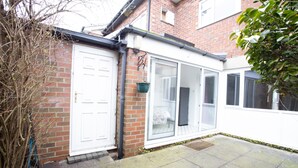 A brick house with a white door and a large sliding glass door. - Hurley House (Cheadle)