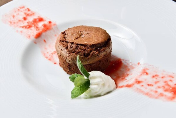 A dessert on a white plate with a red sauce and mint leaves. - Junior Suite (Plitvica Selo)