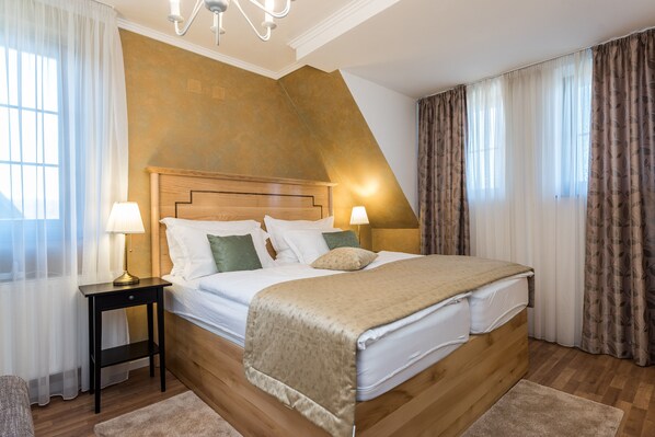 A bedroom with a wooden headboard, a bed with white linens, two bedside lamps, and a small nightstand. - Superior Room (Plitvica Selo)