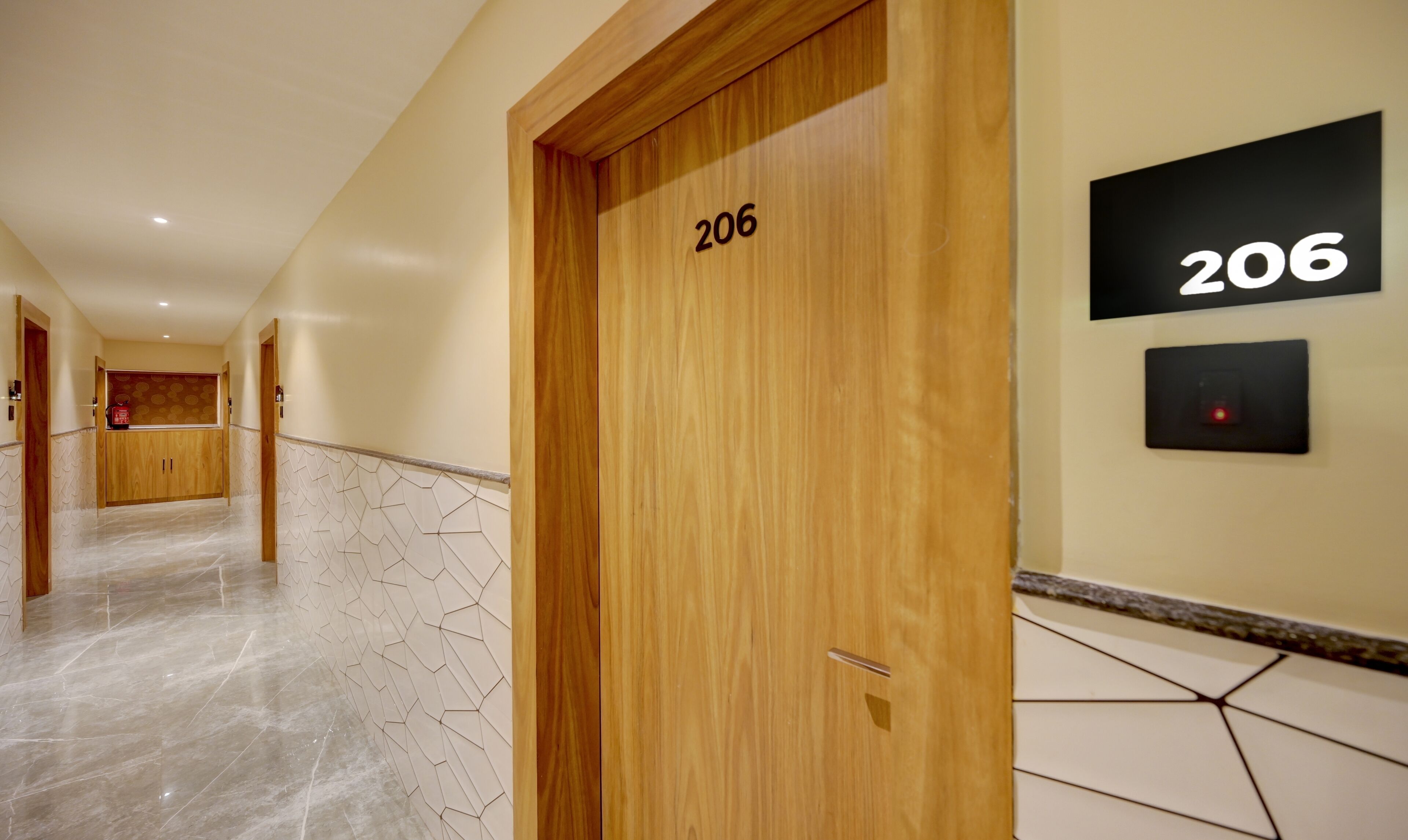A hallway with wooden doors, numbered 206, leading to rooms.