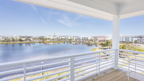 A covered outdoor area with a view of a lake and buildings in the background.