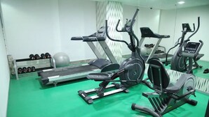 A gym with treadmills, an elliptical, and a bench press. - Best Western Tirupati Hotel (Tirupati)