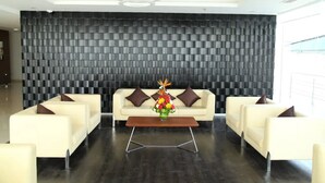 A modern lobby with a checkered wall, a sofa set, and a coffee table with a floral centerpiece. - Best Western Tirupati Hotel (Tirupati)