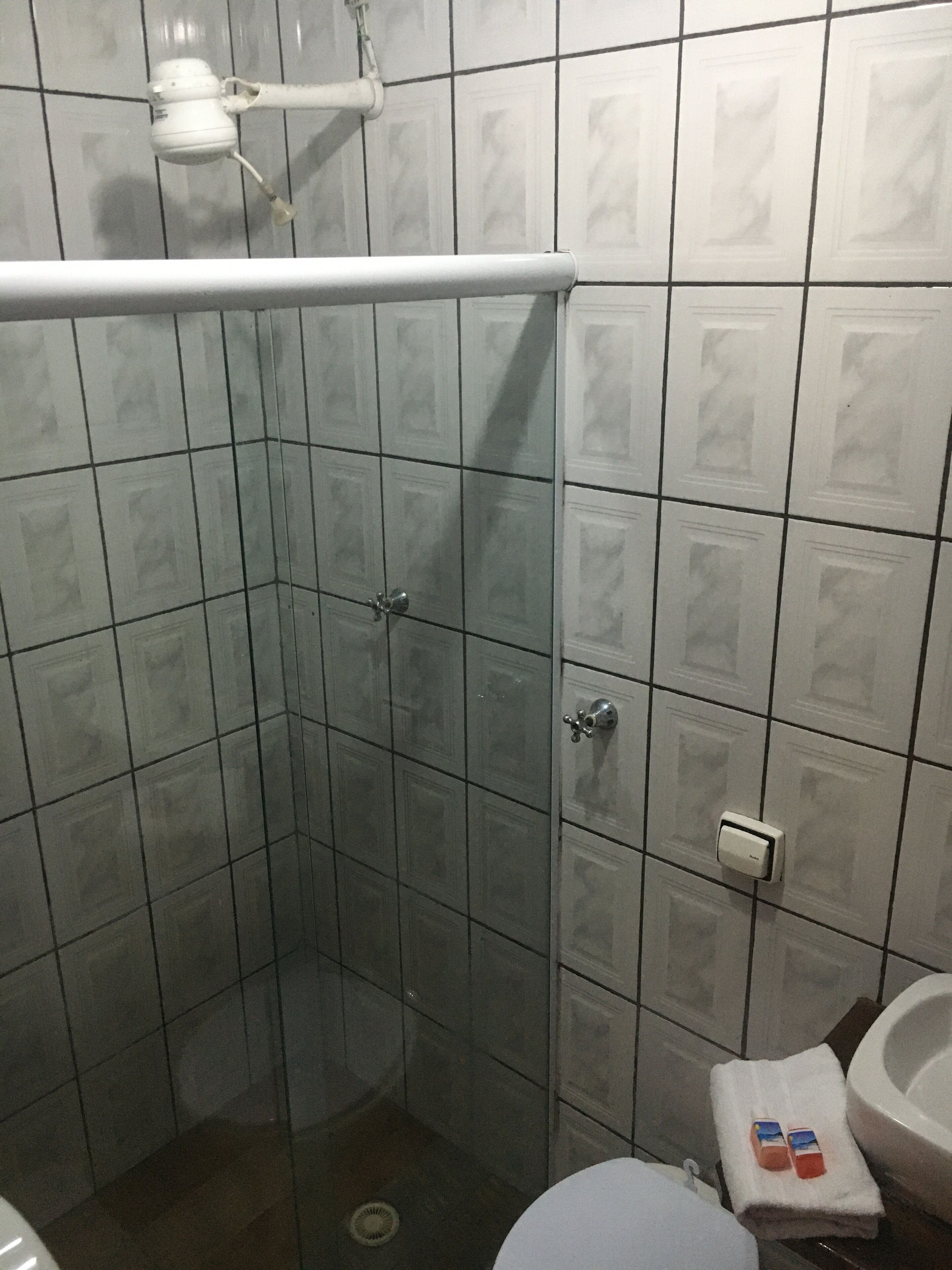 A bathroom with a shower, toilet, and sink.
