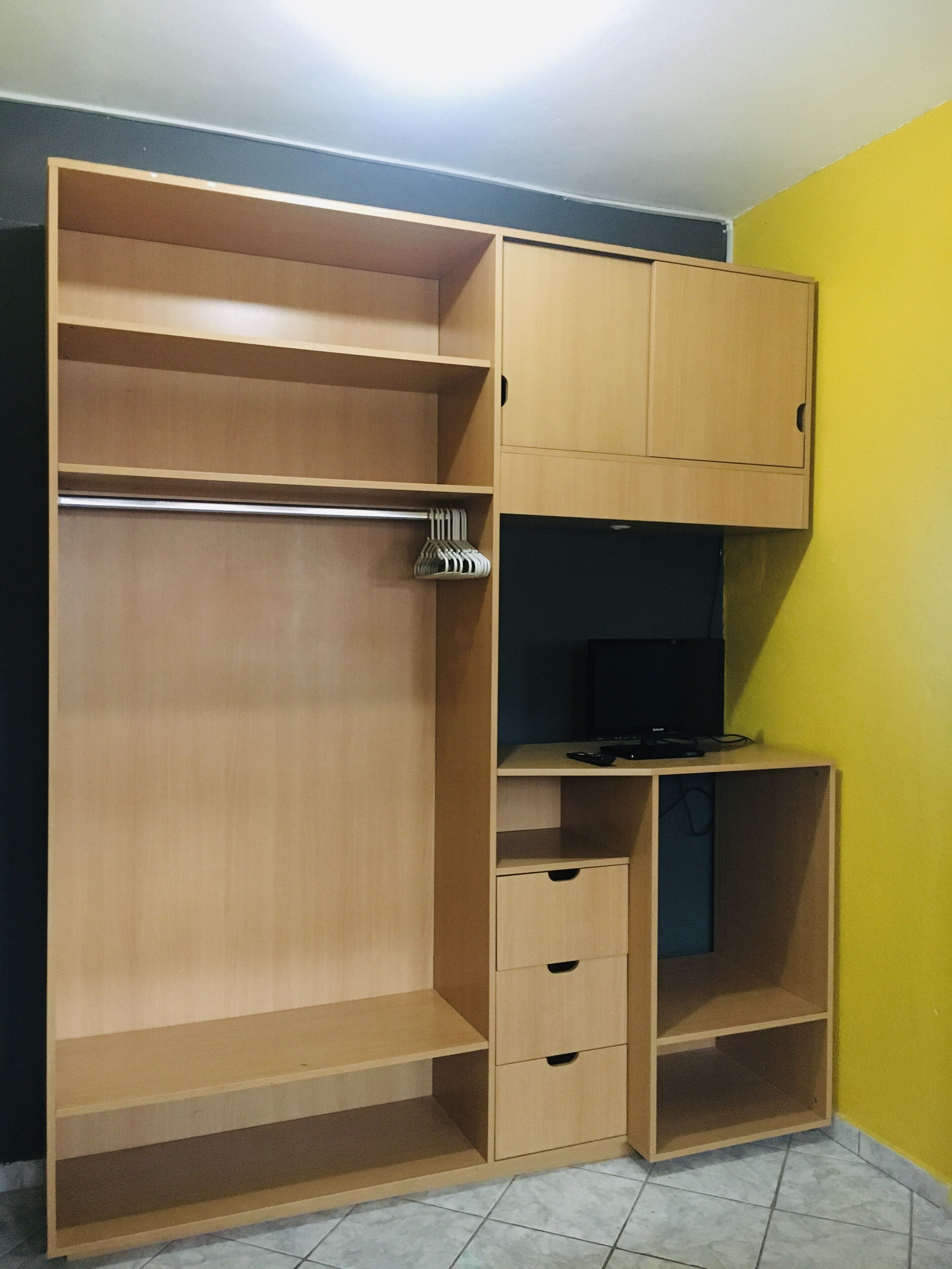 Ein begehbarer Kleiderschrank mit zahlreichen Regalen, Schubladen und Ablageflächen zum Aufhängen.