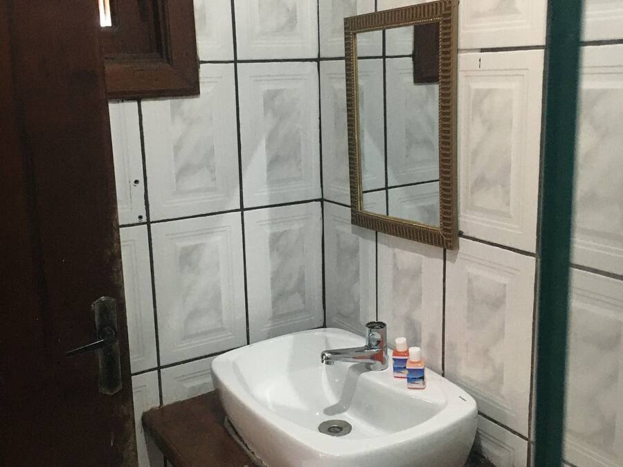 A bathroom with a white sink, a mirror, and a towel on a wooden counter.