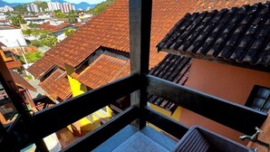 Een balkon met uitzicht op een stadsbeeld, met terracotta daken en een mix van woongebouwen.