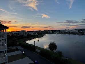 A lakeside residential area with houses, a dock, and a clear sky.