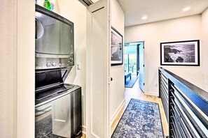 Enter a cozy dining area through this inviting hallway, featuring a stainless steel oven and framed artwork.