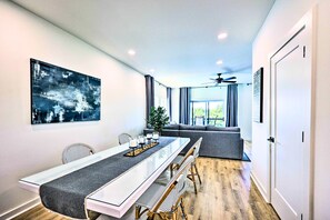Enjoy meals in this stylish dining area with a long table for four, a beautiful abstract painting, and a balcony view.