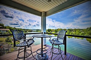 Enjoy a peaceful moment in this elevated outdoor seating area with a table and two chairs, taking in the serene views of the surrounding landscape.
