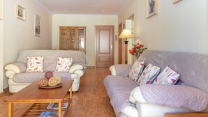 A living room with two sofas, a coffee table, and a cabinet. - Casa Amiga - Communal pool & garden, just 500m from beach (Carvoeiro)