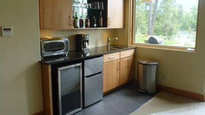 A compact kitchen with a microwave, coffee maker, and a sink.