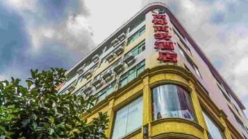 Un edificio de varios pisos con un llamativo letrero rojo en la fachada.