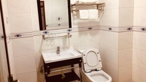 Un bagno con lavandino, WC e specchio.