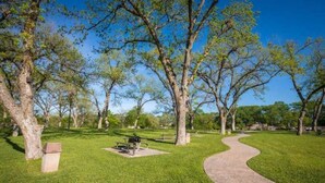 Un parque con un sendero curvo, bancos y árboles.