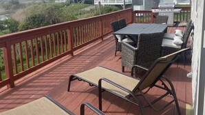 Una terrazza con mobili da esterno, un barbecue e vista sulle case vicine.