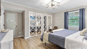 A bedroom with a bed, a desk, a chair, a wardrobe, and a window with curtains. - 3 miles from NAS * King and Queen Bed * Covered Patio * Luxury Bath * Open concept Living (Pensacola)
