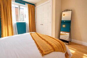 Une chambre à coucher avec un lit, un miroir et des rideaux.